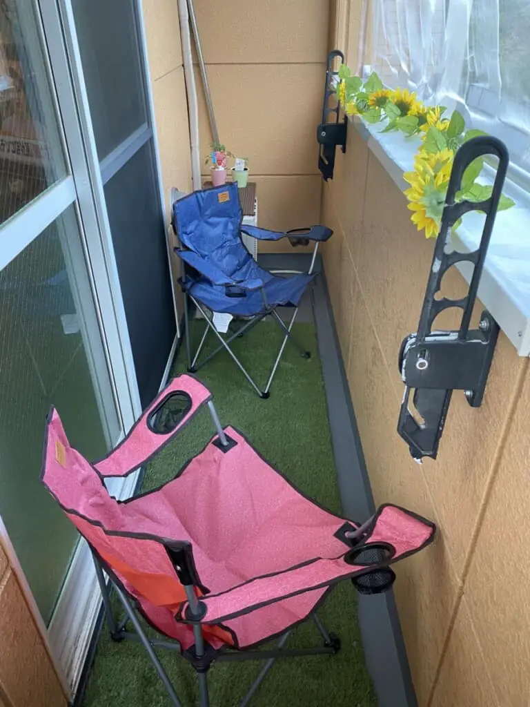 Two camp chairs and fake grass on balcony