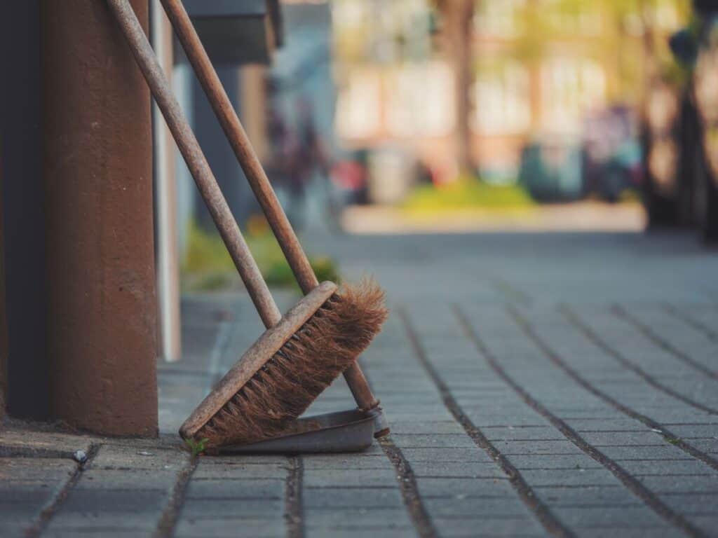 Broom with stiff bristles.