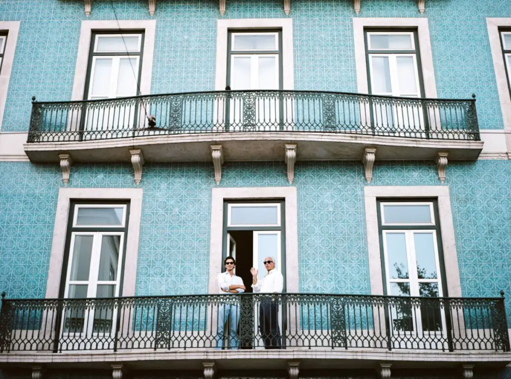 two men standing on a faux balcony