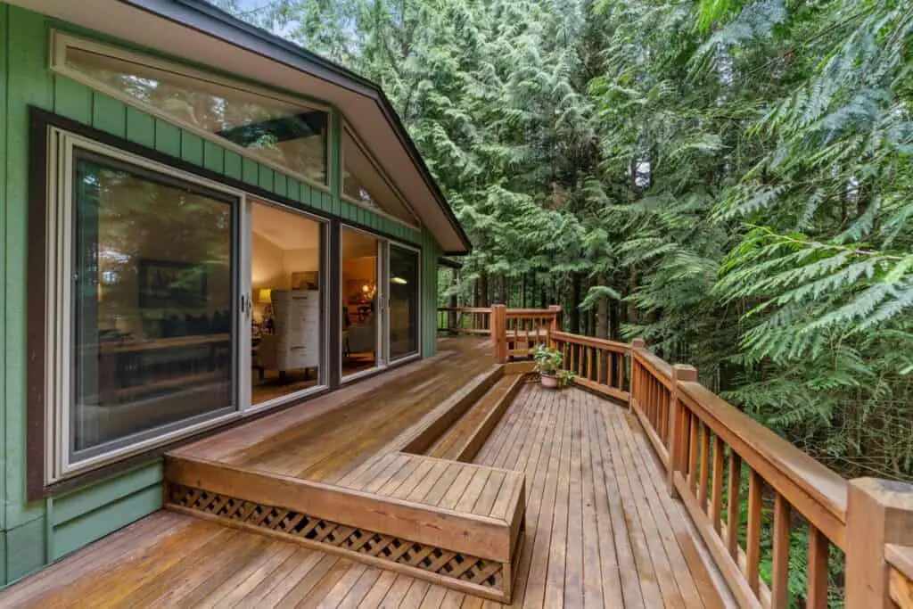 Large wood deck attached to forest home.